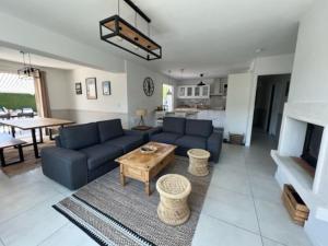 a living room with a blue couch and a table at Maison moderne avec piscine in La Teste-de-Buch