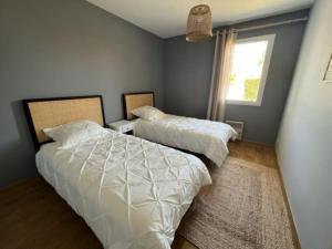 a bedroom with two beds and a window at Maison moderne avec piscine in La Teste-de-Buch +16 photos