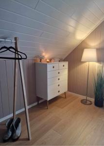 um quarto no sótão com uma cómoda e um candeeiro em Cozy cabin with amazing sauna house em Straumen