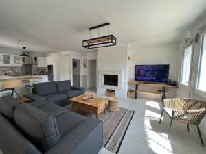 a living room with a couch and a table at Maison moderne avec piscine in La Teste-de-Buch
