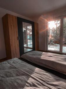 a bedroom with two beds and a large window at Residenz Bergzauber in Ötztal-Bahnhof