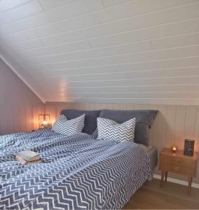 Schlafzimmer mit einem Bett mit gestreifter Decke in der Unterkunft Cozy cabin with amazing sauna house in Straumen