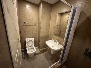 a small bathroom with a toilet and a sink at Immeuble Gazbar in Gabès