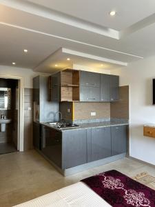 a kitchen with gray cabinets and a counter top at Immeuble Gazbar in Gabès
