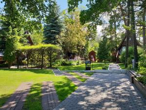 a path in a park with trees and grass at Hotel Zakątek Leśny in Cierpice