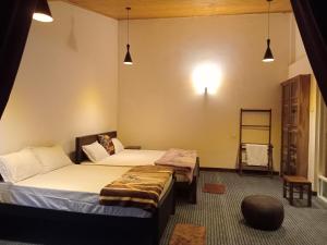 1 dormitorio con 2 camas, estante y luces en Aquaa Leaf Residences, en Nuwara Eliya