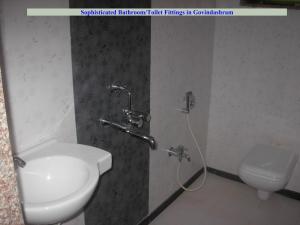La salle de bains est pourvue d'un lavabo et de toilettes. dans l'établissement Govindaashram, à Bhogwe
