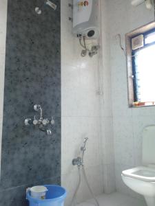 uma casa de banho com um chuveiro e um WC. em Govindaashram em Bhogwe