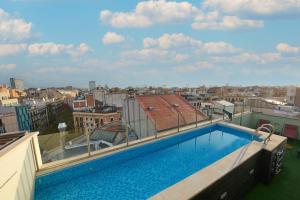 a swimming pool on the roof of a building at 1881 Barcelona Gran Rosellon Hotel in Barcelona