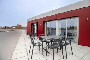 a patio with a table and chairs on a roof at Lumen by coliving in Renens
