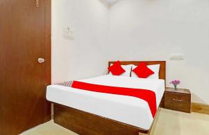 a bedroom with a large bed with red pillows at Hotel O R Square Near LB Nagar Metro Station in Hyderabad