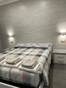 1 dormitorio con 1 cama con toallas en La Divina Holiday, en Rávena