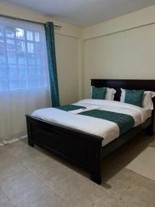 a large bed in a room with a window at The comfortplace oak 102 in Kericho