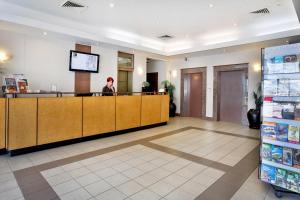 a woman standing at the cash register of a pharmacy at Madison Plaza Townsville in Townsville