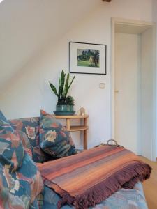 uma sala de estar com um sofá com um cobertor em FeWo Weitblick in Höhenlage von Greiz em Greiz