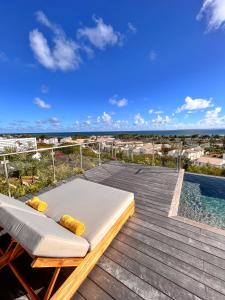 een bed op een terras naast een zwembad bij Résidence Les Raisins Clairs - Villas standing 4 étoiles , vue sur mer panoramique & piscine à débordement in Saint-François