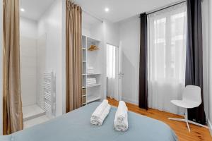 1 dormitorio blanco con 1 cama y 1 silla en Le Cocon - T2 Cosy hypercentre avec parking, en Toulouse