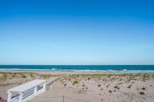 a white bench sitting on top of a beach at Spray Beach Hotel in Beach Haven