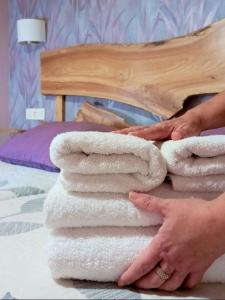 a woman is stacking towels on a bed at Casa rural Abascal in Cella