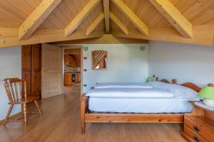 1 dormitorio con 1 cama grande y techo de madera en Agritur Cristina, en Coredo
