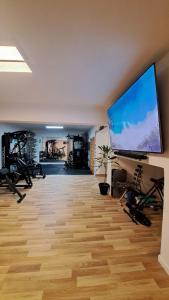 a large room with a gym with a flat screen tv at B&B Confort in Reggio Calabria