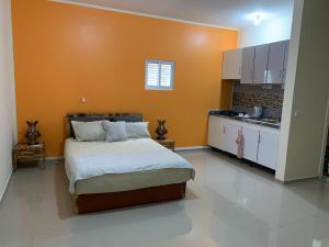 1 dormitorio con 1 cama grande y cocina en J Martins Apart Hotel en Tarrafal