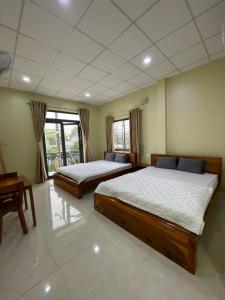 - une chambre avec 2 lits et une table dans l'établissement Nhà nghỉ Hoa Dũng, à Hà Tiên