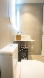 La salle de bains est pourvue de toilettes blanches et d'un lavabo. dans l'établissement Casa Pince, à Barcelone