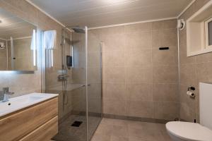 a bathroom with a shower and a toilet and a sink at Aurora Borealis Observatory in Silsand
