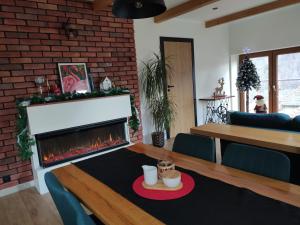 a living room with a fireplace and a table and chairs at Apartament Góry Bardzkie in Bardo