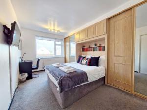 a bedroom with a large bed and a television at Sea Scene's , Hayling Island in South Hayling