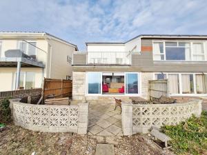 a house with a stone fence in front of it at Sea Scene's , Hayling Island in South Hayling