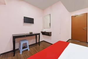 a bedroom with a bed and a desk and a tv at Seri Mawardah Hotel in Malacca