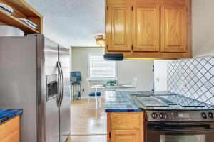 a kitchen with a stainless steel refrigerator and wooden cabinets at Panama City Waterfront Escape Fenced Yard and Dock! in Panama City