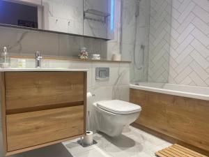 a bathroom with a toilet and a sink and a tub at Stunning Apartment in Manchester City Centre in Manchester