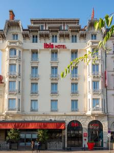 - un grand bâtiment blanc avec un panneau d'hôtel dans l'établissement ibis Lyon Centre Perrache, à Lyon