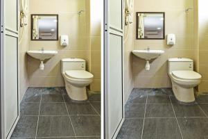 een badkamer met 2 toiletten en 2 wastafels en spiegels bij Mawardah Hotel Melaka Raya in Melaka