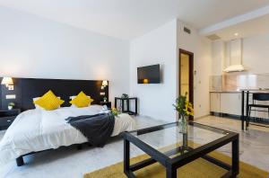 1 dormitorio con cama y mesa de cristal en LuxSevilla Piscina Parking Gratis en Bormujos