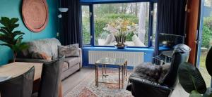 sala de estar con sofá, sillas y mesa en Chalet Veluwe G10 Veldkamp 4 Personen, en Epe