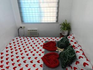 1 dormitorio con 1 cama con almohadas rojas y verdes en Amigas Lodge, en Santo Tomás