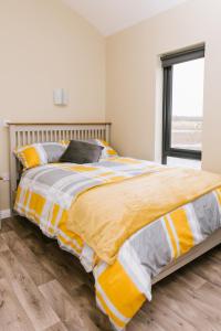 sypialnia z dużym łóżkiem z żółtą i białą pościelą w obiekcie Easkey Glamping Village w mieście Easkey