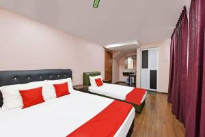 una camera con due letti con cuscini rossi e bianchi di Mawardah Hotel Melaka Raya a Malacca