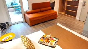 a living room with a couch and a tray of food at Avia Hôtel Saphir Montparnasse in Paris