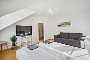 uma sala de estar com uma cama e um sofá em home2stay Apartmenthaus Dresden em Dresden
