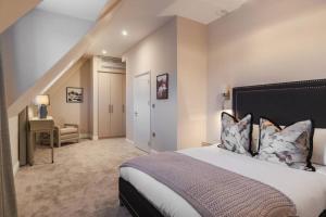 um quarto com uma cama grande e uma escada em Spacious Luxury Penthouse, 2BR, Private Parking em Windsor