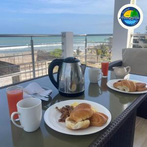 una mesa con dos platos de comida en una mesa con la playa en Hotel Pinos del Mar, en Zorritos