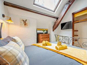 a bedroom with a bed with yellow pillows at 2 Bed in Lanhydrock 90216 in Bodmin