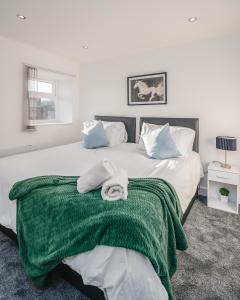 a bedroom with two beds with towels on them at Contractors I Working professionals I Relocators - Near Train Station and Airport in Luton