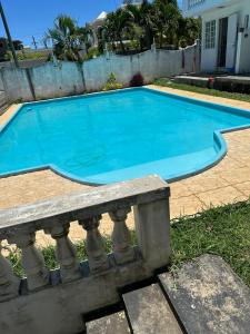 a large blue swimming pool with a stone railing at Residence Loisirs in Pereybere