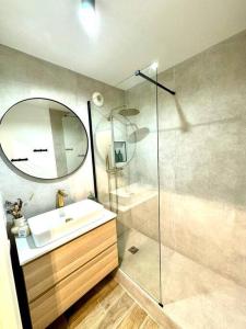 a bathroom with a sink and a shower with a mirror at New Disneyland Paris Serena Apartment in Bussy-Saint-Georges